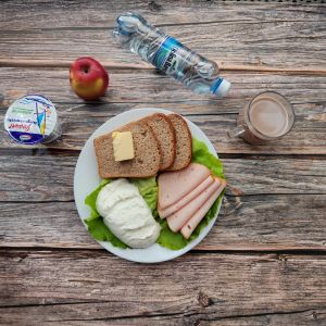 Zdjęcie przedstawia Dietę z ograniczeniem łatwoprzyswajalnych węglowodanów  Kakao Chleb Graham Masło extra Filet zapiekany drobiowy Jogurt naturalny Jabłko Woda mineralna Sałata zielona Twarożek